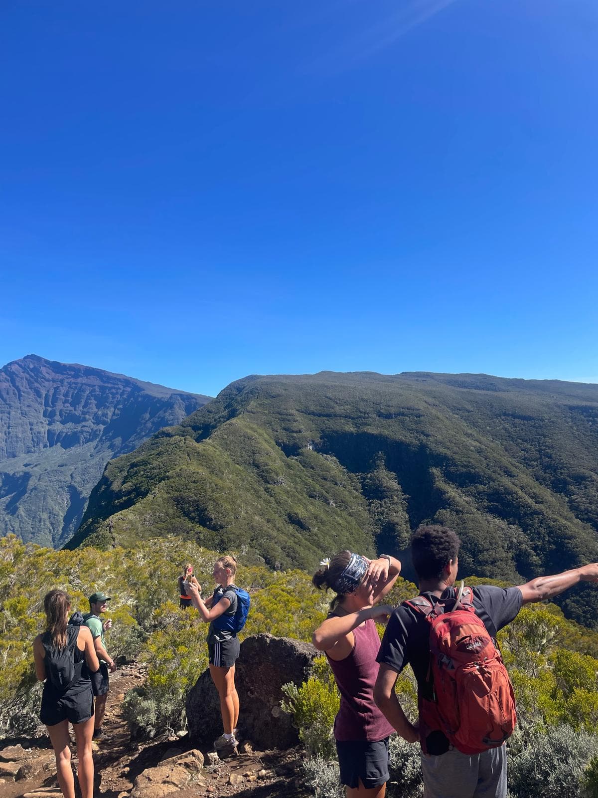 Randonneurs au sommet face aux montagnes de Mafate